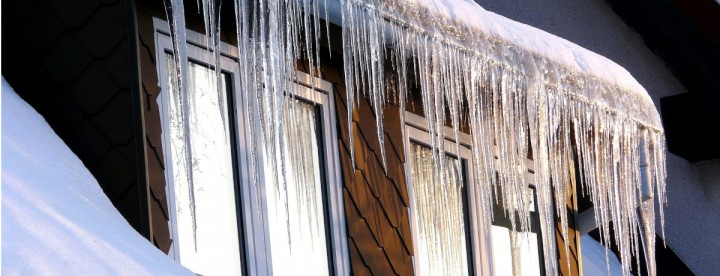 Long icicles hanging from the roof above a window on a Montreal house during winter – De longues stalactites de glace pendent du toit au-dessus d’une fenêtre d’une maison à Montréal en hiver.