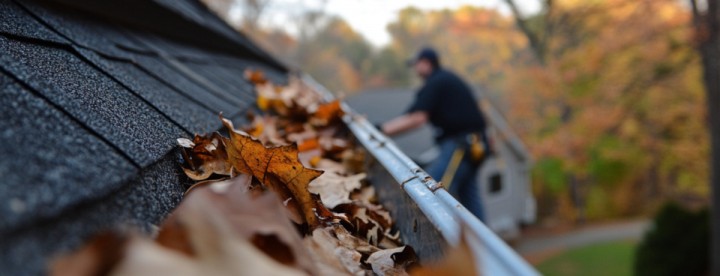 Homeowner cleaning gutters as part of fall home maintenance. Propriétaire nettoyant les gouttières dans le cadre de l’entretien automnal de sa maison.